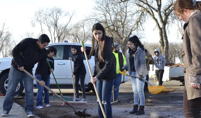 College of Idaho students help clean streets and gutters at Farmway Village as part of a service project.