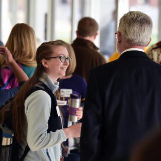 Young woman talking to man in suit