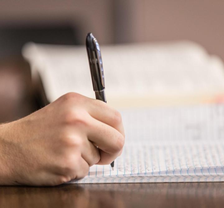 Person writing in book