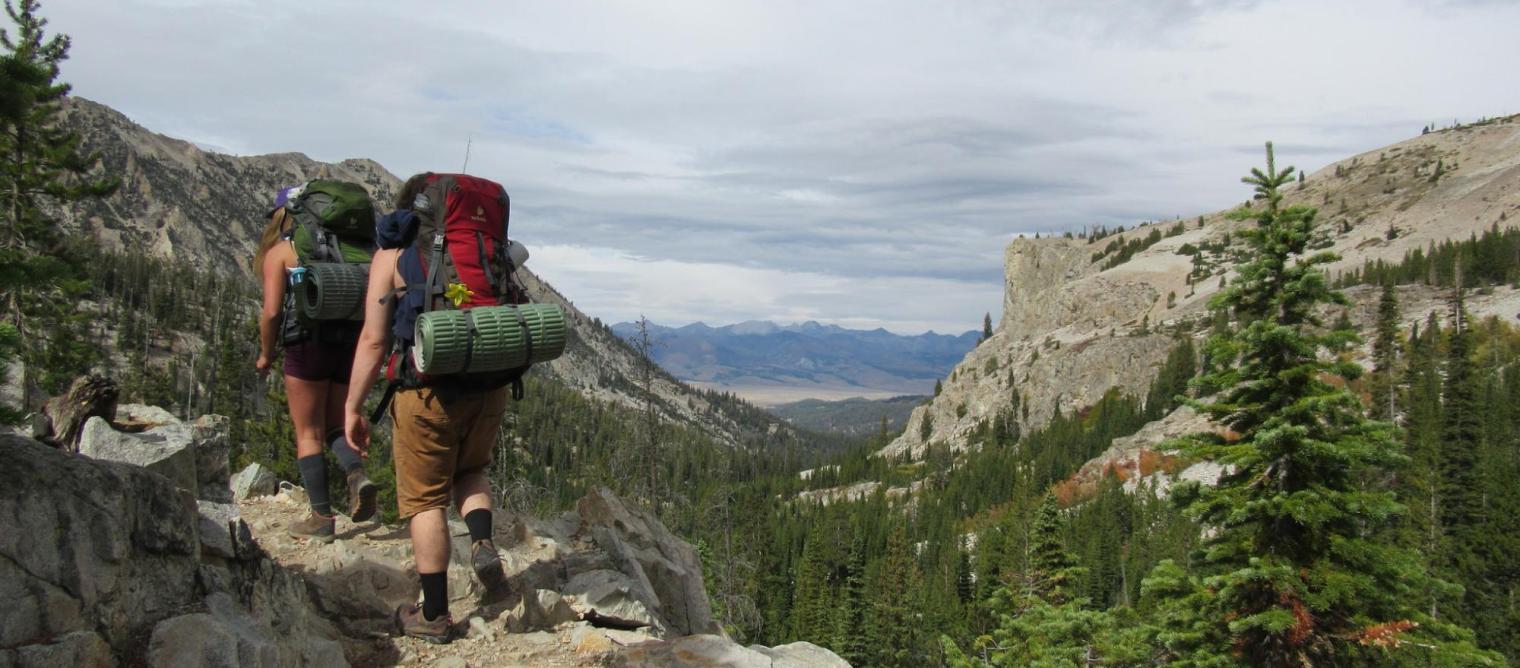 Two students hike a mountain trail