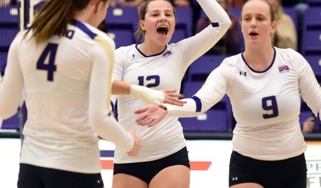 Volleyball players cheer after scoring a point