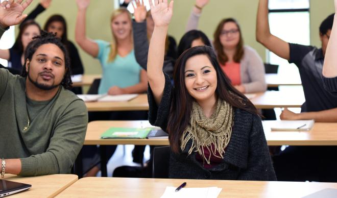 Students raise their hands in a C of I classroom