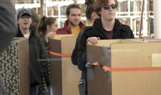 A group of C of I students cart books to new shelves inside the Cruzen-Murray Library