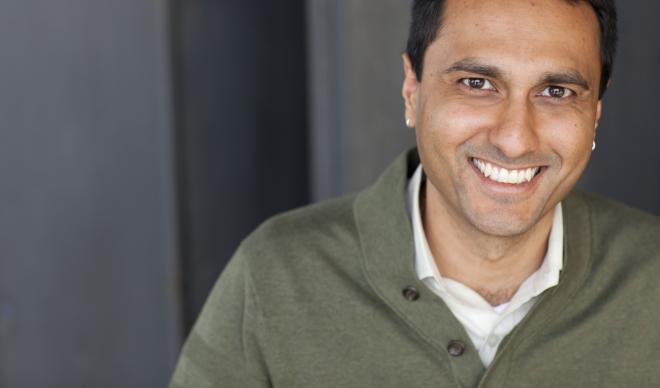 Portrait of Dr. Eboo Patel smiling on a neutral background.