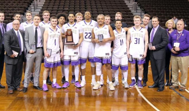 The Yotes men's basketball team poses with hardware earned at the NAIA Division II Men's Basketball Championships.