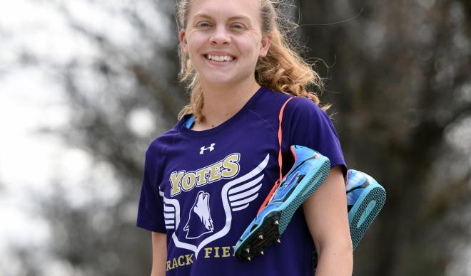 Sophomore Molly Vitale-Sullivan poses with running shoes on the College of Idaho campus.