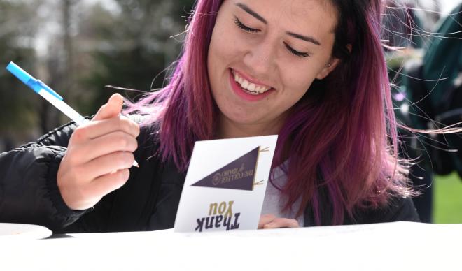 A student signs a thank-you note during Giving Day 2018.