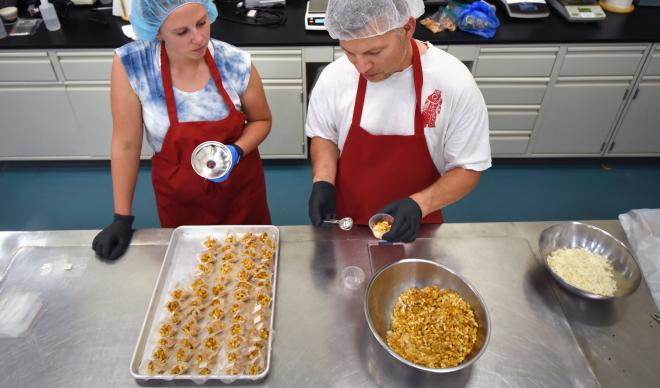 Megan French (left) and Dr. Jeff Snyder-Reinke (right) pack tea bags for Voće Tea at the University of Idaho Food Technology Center.