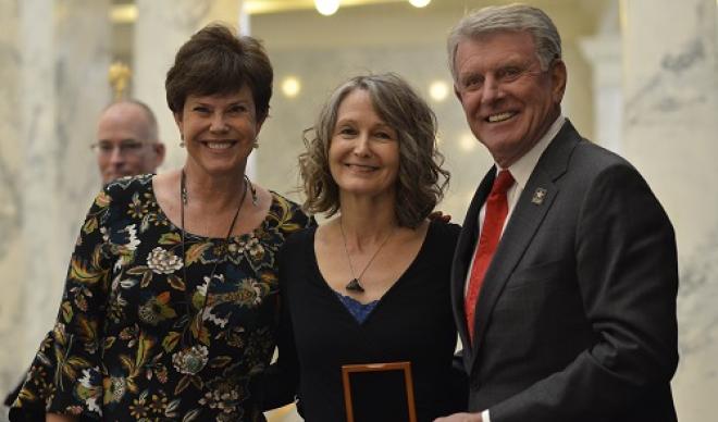 Diane Raptosh (center) receives the Governor's Award for Excellence in the Arts from Lori (left) and Butch Otter (right).