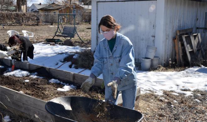 Student cleaning community garden
