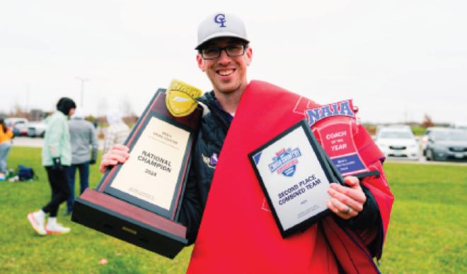 Coach Dom Bolin holding up NAIA Trophy 