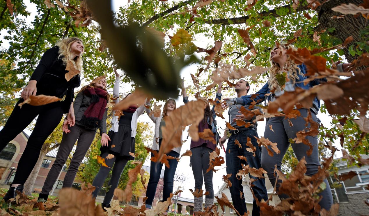 Students throwing leaves in the air