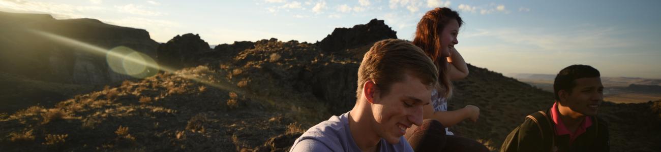 Students sitting at sunset