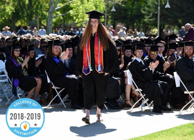 A C of I student at the 2018 Commencement featuring a 2018-2019 "Colleges of Distinction" badge.